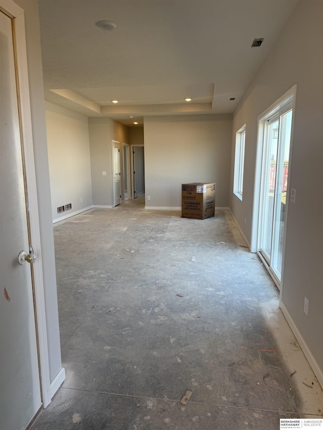spare room featuring baseboards, visible vents, recessed lighting, and a raised ceiling