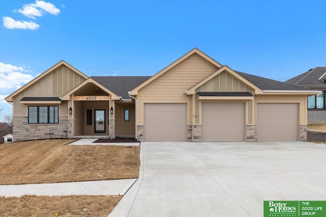 craftsman house with a garage, stone siding, driveway, and board and batten siding