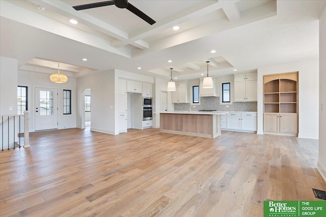 kitchen featuring a large island, white cabinetry, light countertops, and open floor plan