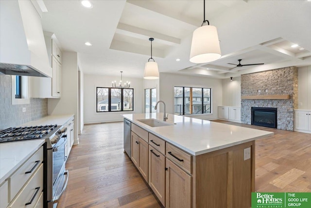 kitchen featuring white cabinets, stainless steel appliances, a spacious island, and sink