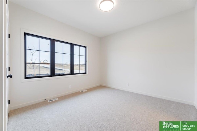 empty room with carpet floors, baseboards, and visible vents