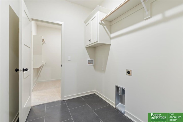 laundry area with hookup for a washing machine, cabinet space, hookup for an electric dryer, dark tile patterned flooring, and baseboards