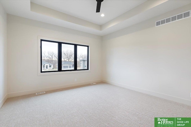 unfurnished room featuring carpet floors, baseboards, visible vents, and a tray ceiling