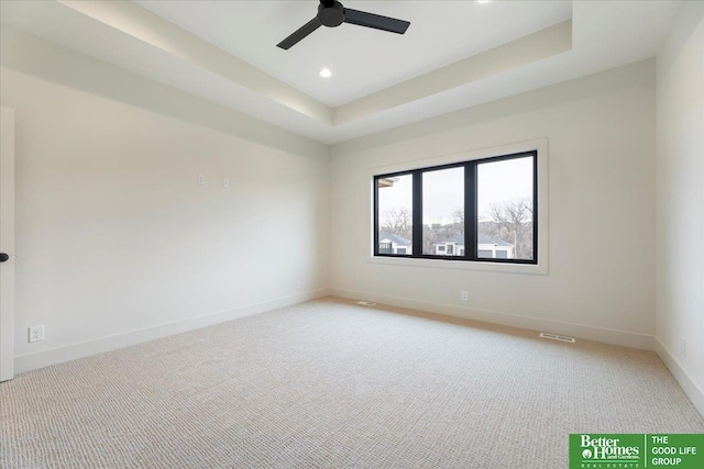 carpeted spare room with ceiling fan, recessed lighting, visible vents, baseboards, and a raised ceiling