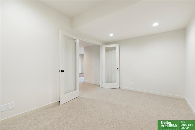 empty room with light carpet, baseboards, and recessed lighting