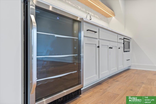 interior details with hardwood / wood-style floors and beverage cooler