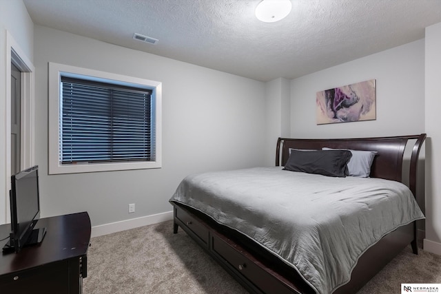 bedroom featuring light colored carpet and a textured ceiling