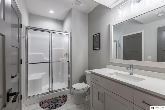 bathroom with vanity, toilet, and a shower with door