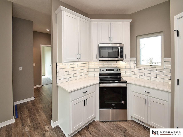 kitchen with backsplash, white cabinetry, dark hardwood / wood-style flooring, and stainless steel appliances