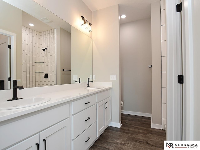 bathroom with toilet, vanity, and hardwood / wood-style flooring