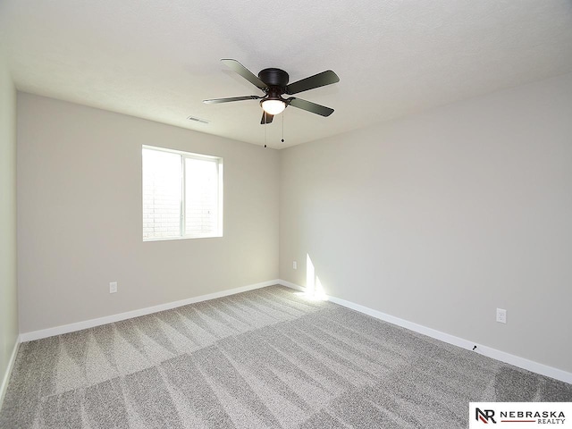 carpeted spare room featuring ceiling fan and a textured ceiling