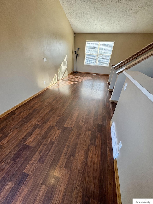 unfurnished living room with dark hardwood / wood-style floors and a textured ceiling