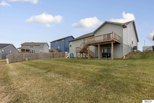 rear view of property featuring a lawn, cooling unit, and a deck