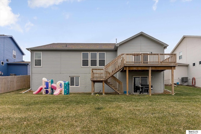 back of property with a lawn, a wooden deck, and central AC unit