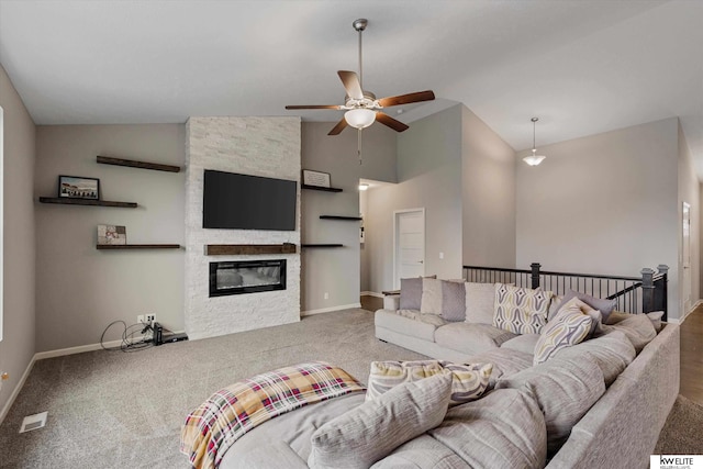 carpeted living room with high vaulted ceiling, a stone fireplace, and ceiling fan