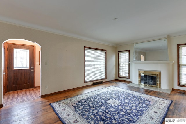 living room with a healthy amount of sunlight, wood-type flooring, and crown molding