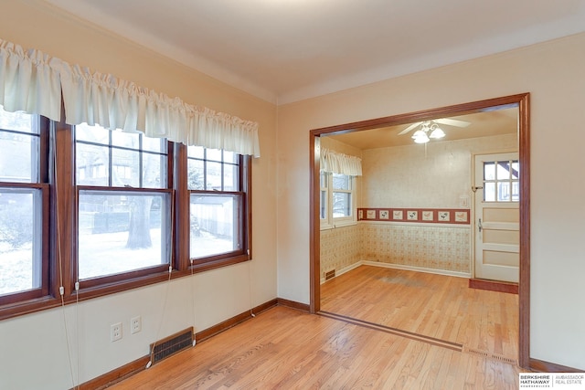 empty room with ceiling fan and light hardwood / wood-style flooring