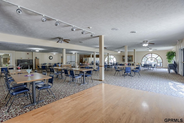 dining space with hardwood / wood-style floors, ceiling fan, and a textured ceiling