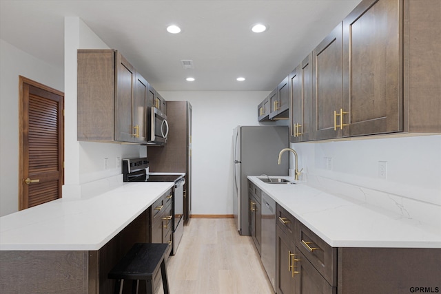 kitchen with sink, stainless steel appliances, dark brown cabinets, and light wood-type flooring