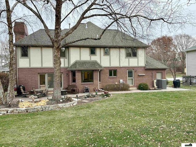 rear view of property featuring central air condition unit, a patio area, and a lawn