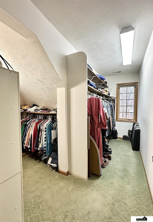 walk in closet featuring light carpet