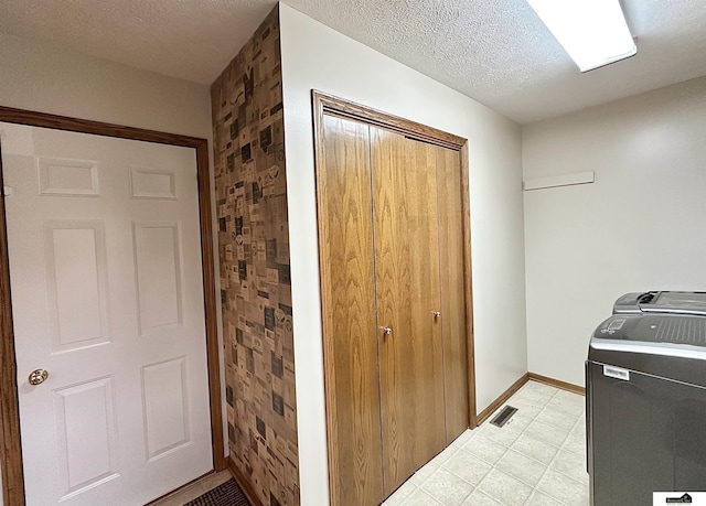 laundry room featuring separate washer and dryer and a textured ceiling