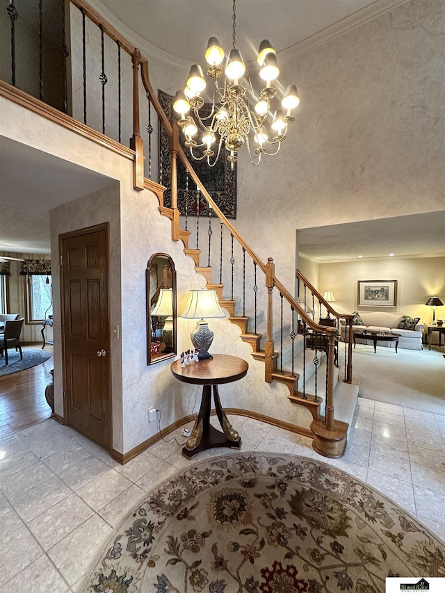 staircase featuring ornamental molding, a high ceiling, and an inviting chandelier