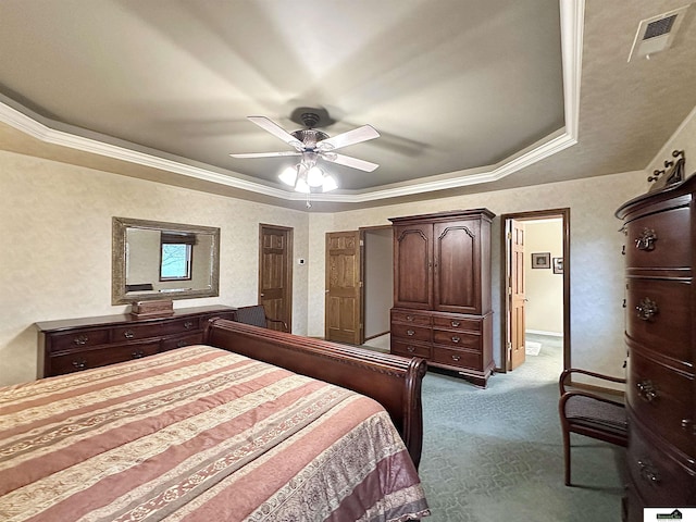 bedroom featuring ceiling fan, crown molding, light carpet, and a tray ceiling