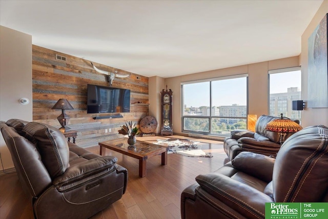 living room featuring hardwood / wood-style floors and wooden walls