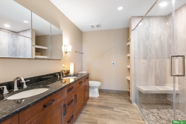 bathroom with vanity, toilet, and a shower with shower door