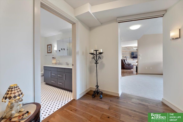 corridor featuring sink and light hardwood / wood-style floors