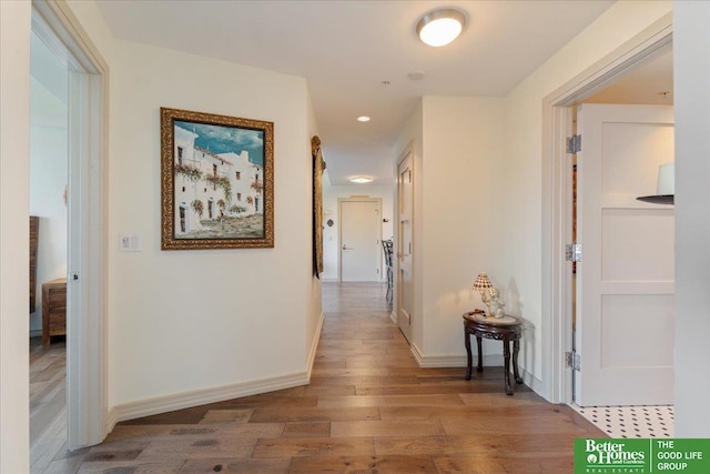 corridor with hardwood / wood-style flooring