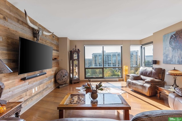 living room with hardwood / wood-style floors and wood walls