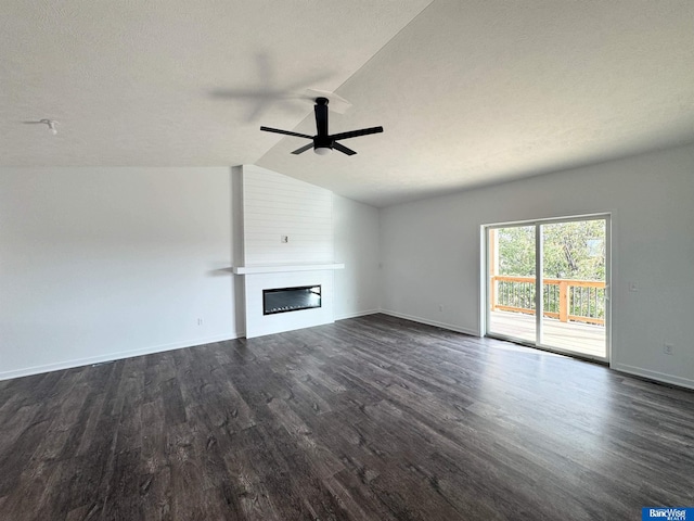 unfurnished living room featuring dark hardwood / wood-style floors, a large fireplace, ceiling fan, and vaulted ceiling