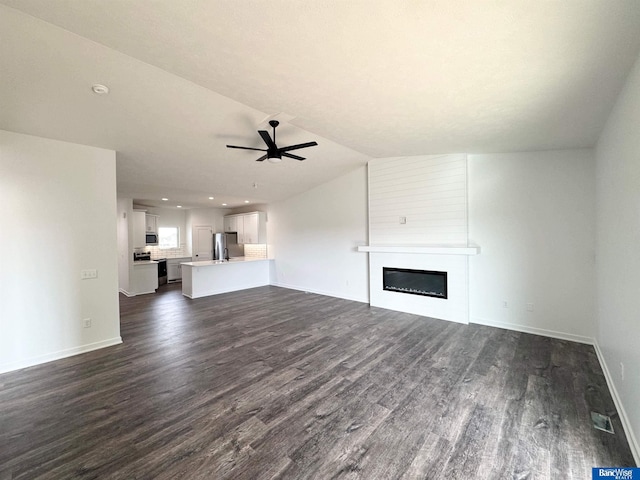 unfurnished living room featuring lofted ceiling, a fireplace, ceiling fan, and dark hardwood / wood-style floors