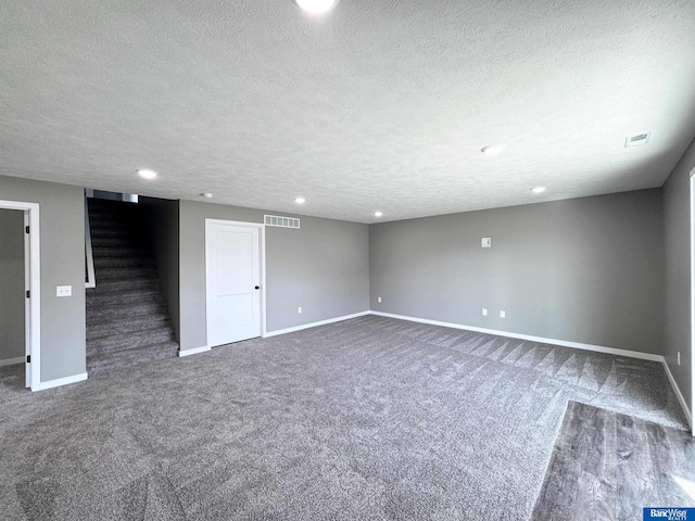 carpeted empty room featuring a textured ceiling