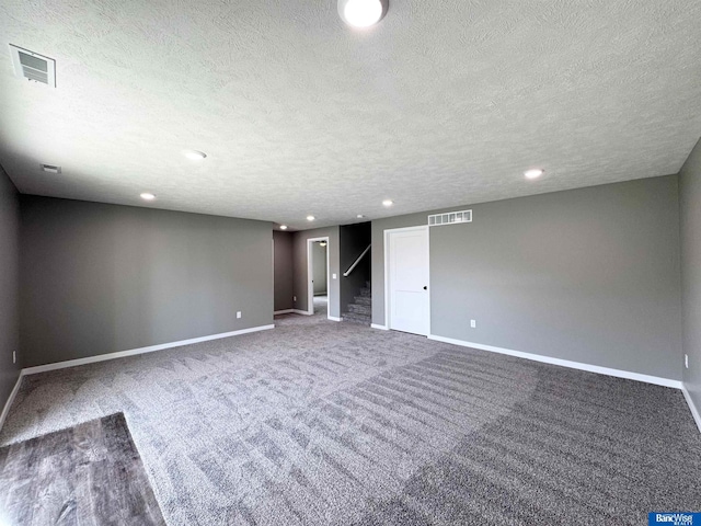 carpeted spare room with a textured ceiling