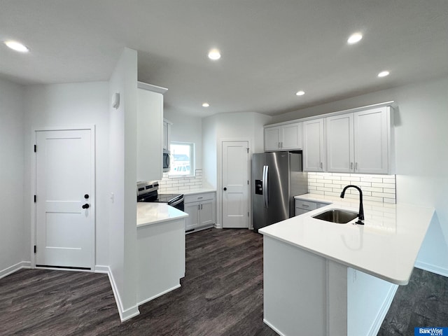 kitchen featuring backsplash, sink, white cabinets, and appliances with stainless steel finishes