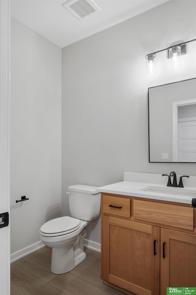 bathroom with vanity, wood-type flooring, and toilet