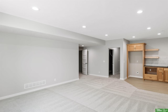 unfurnished living room with light colored carpet