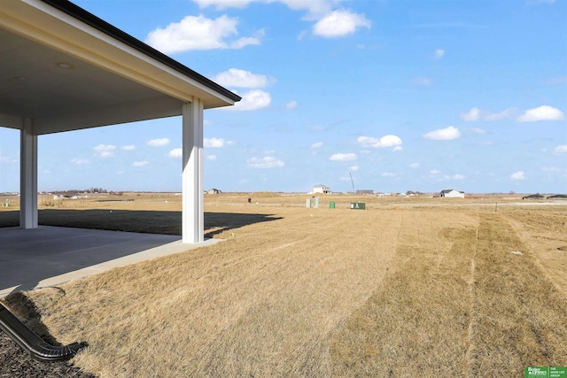 view of yard with a rural view and a patio