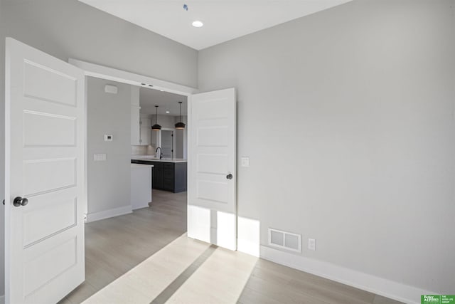 empty room with sink and light wood-type flooring