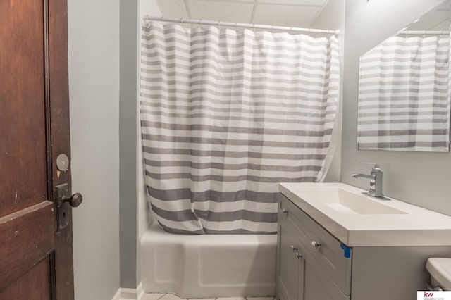 bathroom with shower / bath combination with curtain, vanity, and a drop ceiling