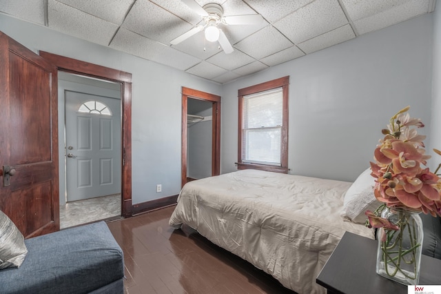 bedroom with a paneled ceiling, a closet, and ceiling fan