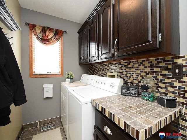 laundry area with washer and clothes dryer and cabinets