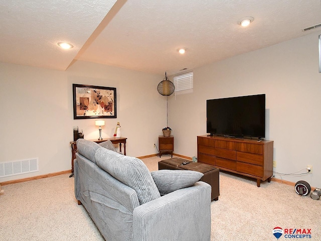 living room with a textured ceiling and light carpet