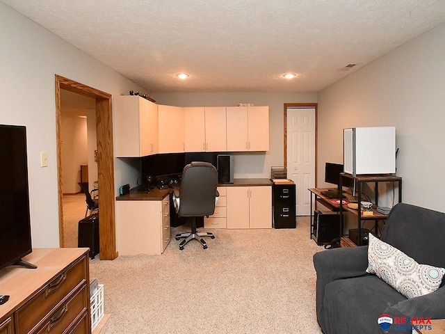 carpeted home office with a textured ceiling