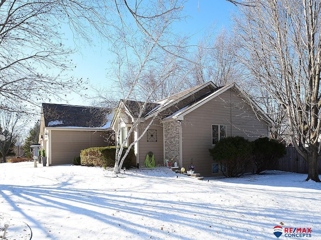 view of snow covered exterior with a garage