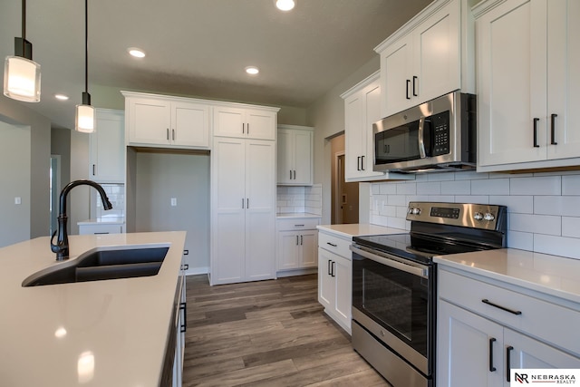 kitchen featuring pendant lighting, white cabinets, sink, and stainless steel appliances