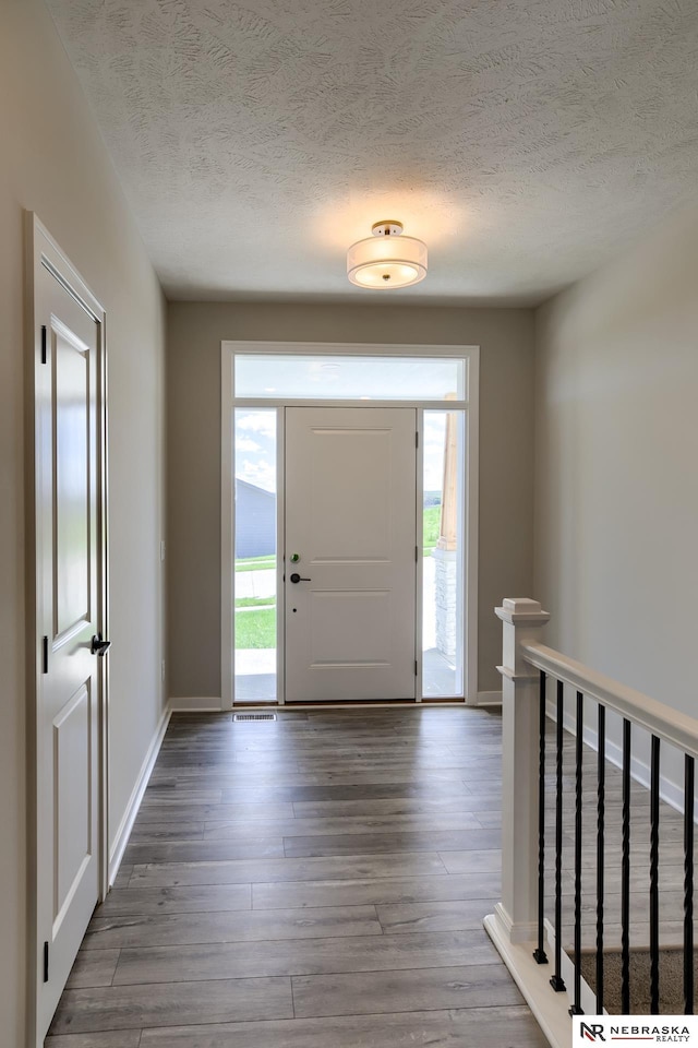 entrance foyer with wood-type flooring and a textured ceiling